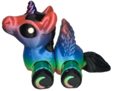 A 3D-printed articulated alicorn hatchling figure with flexible, segmented joints, small feathered wings, and a tiny spiraled horn, resting upright on a flat surface.
